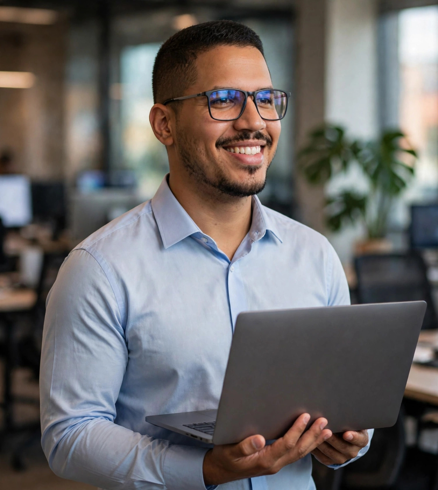 Julio Junior engenheiro de software, camisa social azul-clara com notebook, escritório de tecnologia ao fundo
